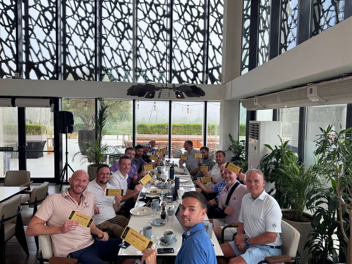 Members around the breakfast table holding up their Golden Tickets